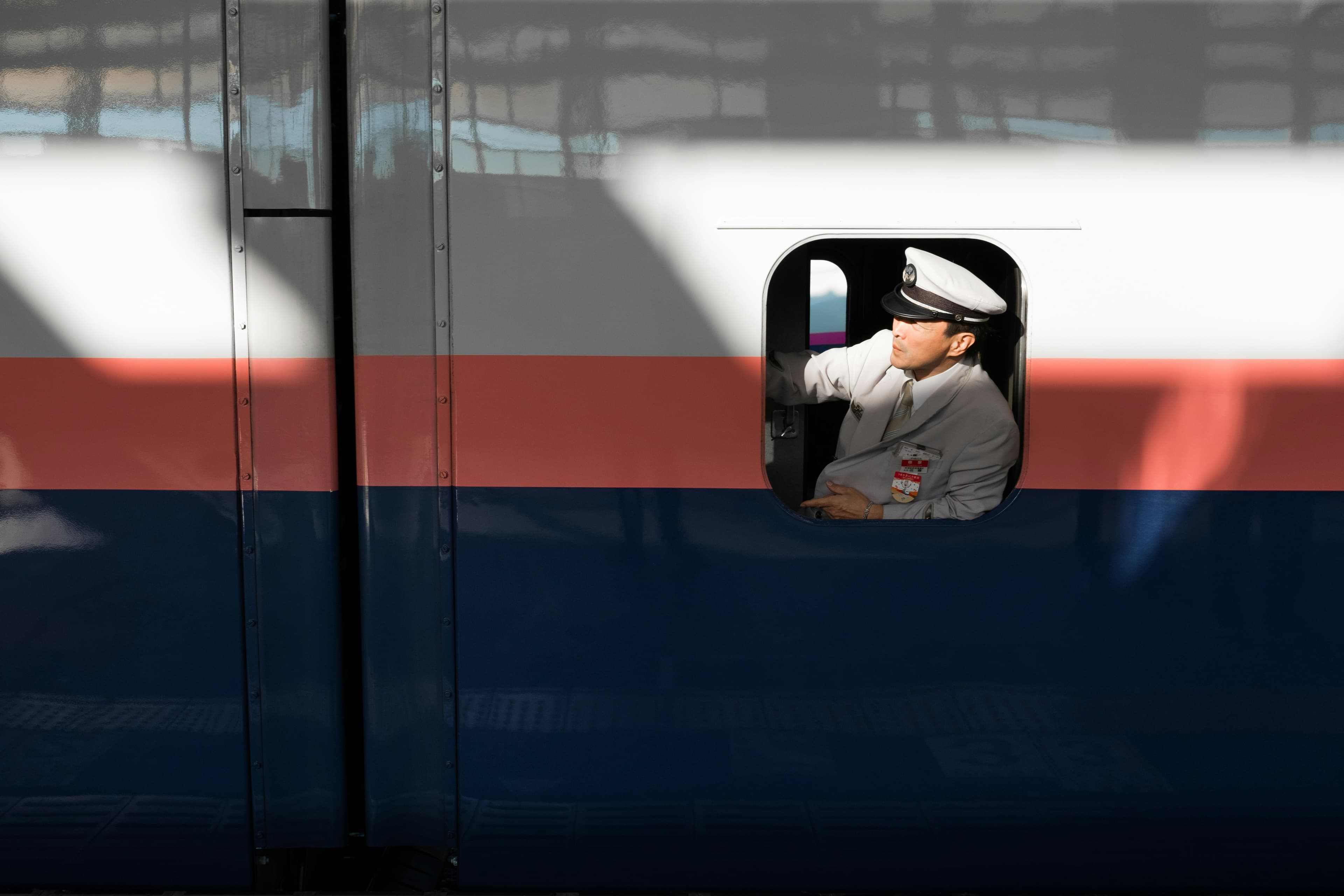Train conductor assisting travelers in Japan