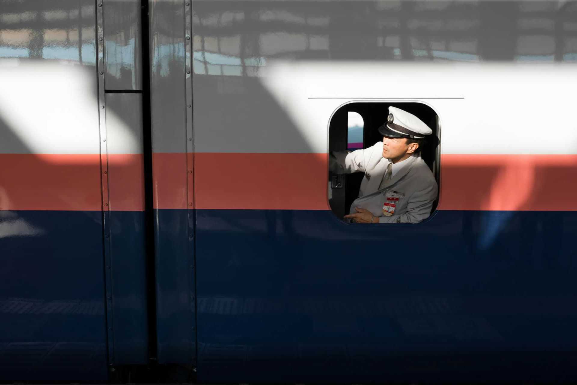 Train conductor assisting travelers in Japan