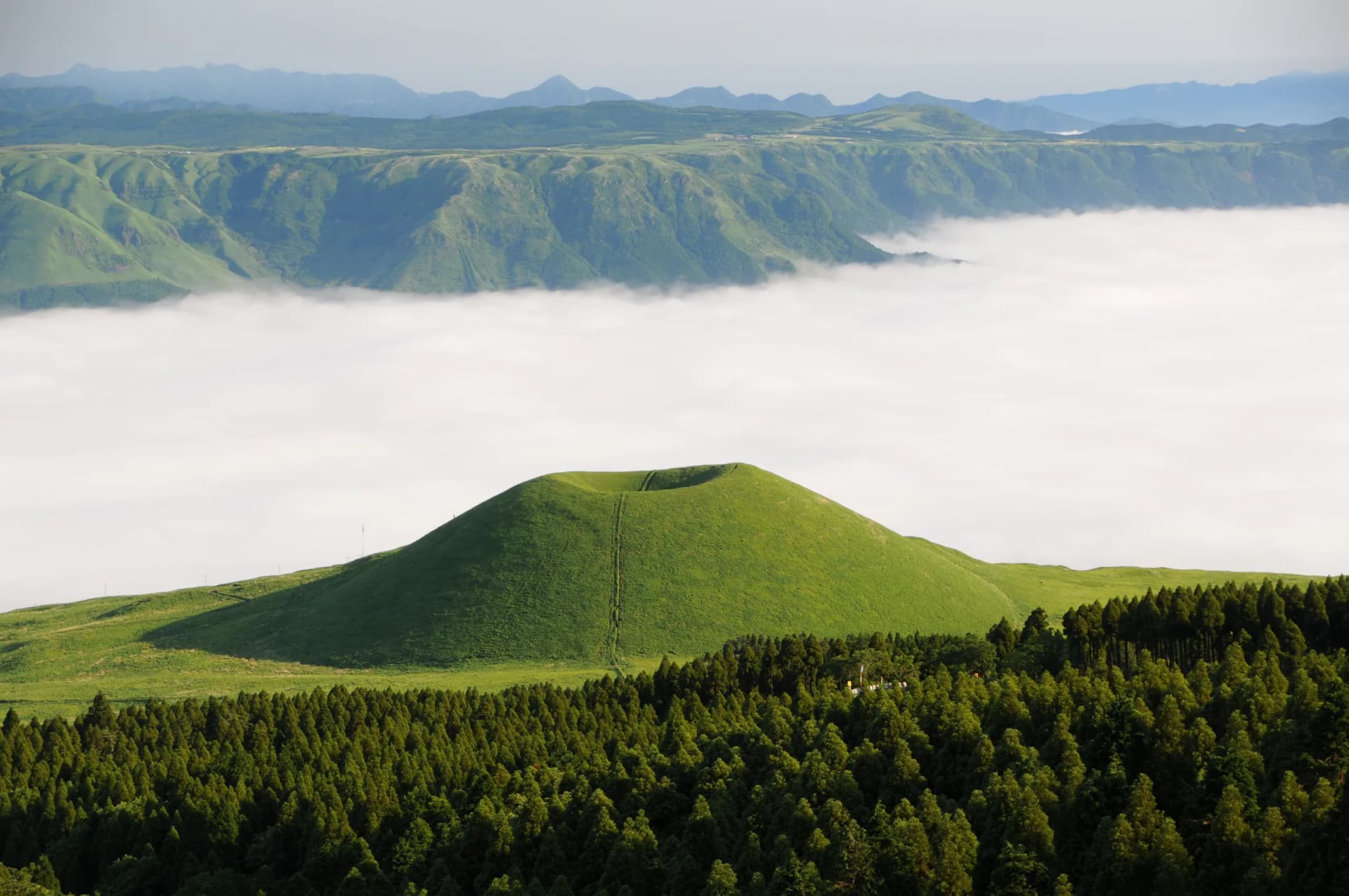 Komezuka volcanic cone rising above the green Aso landscape in Kumamoto