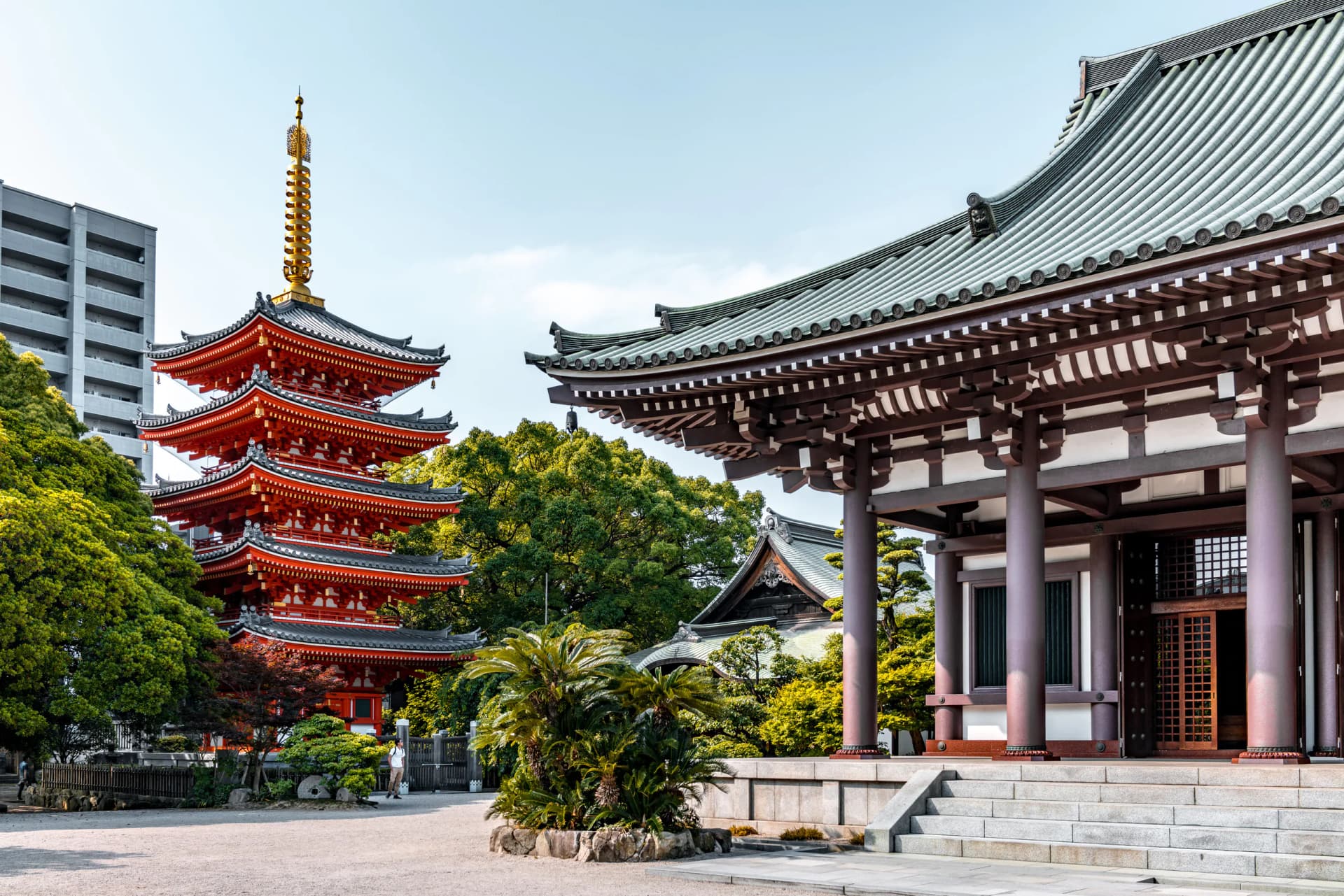 Tochoji Temple's red five-story pagoda beside the main temple building in Fukuoka