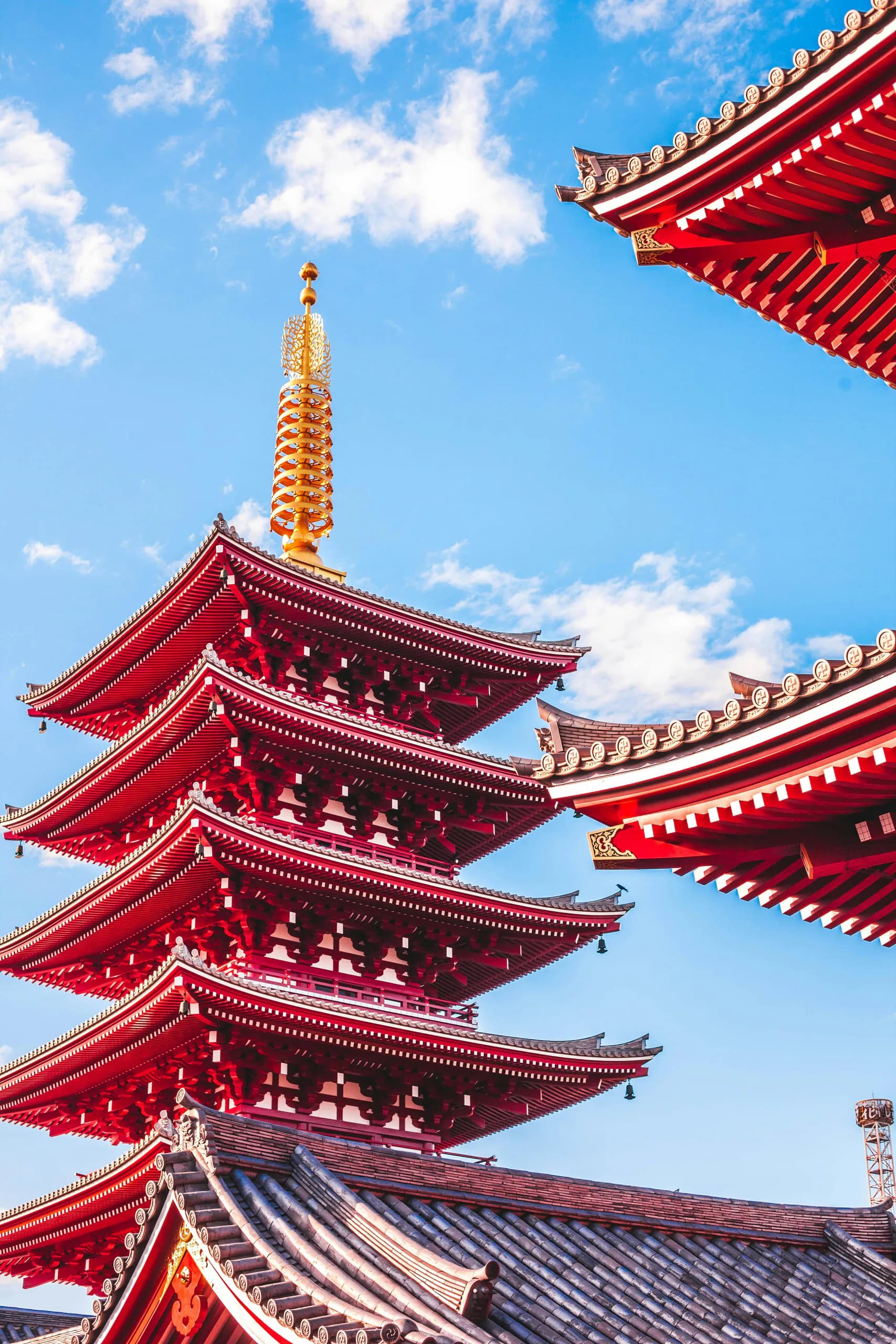 Senso-ji's red pagoda and temple roofs beneath a blue sky in Asakusa