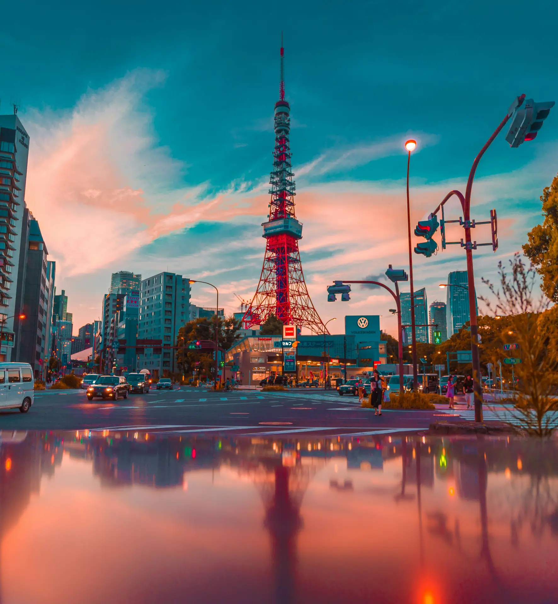 Tokyo Tower with a pink and orange sky reflected in water